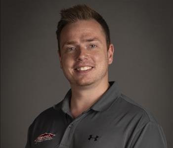 Male wearing gray polo in front of gray background